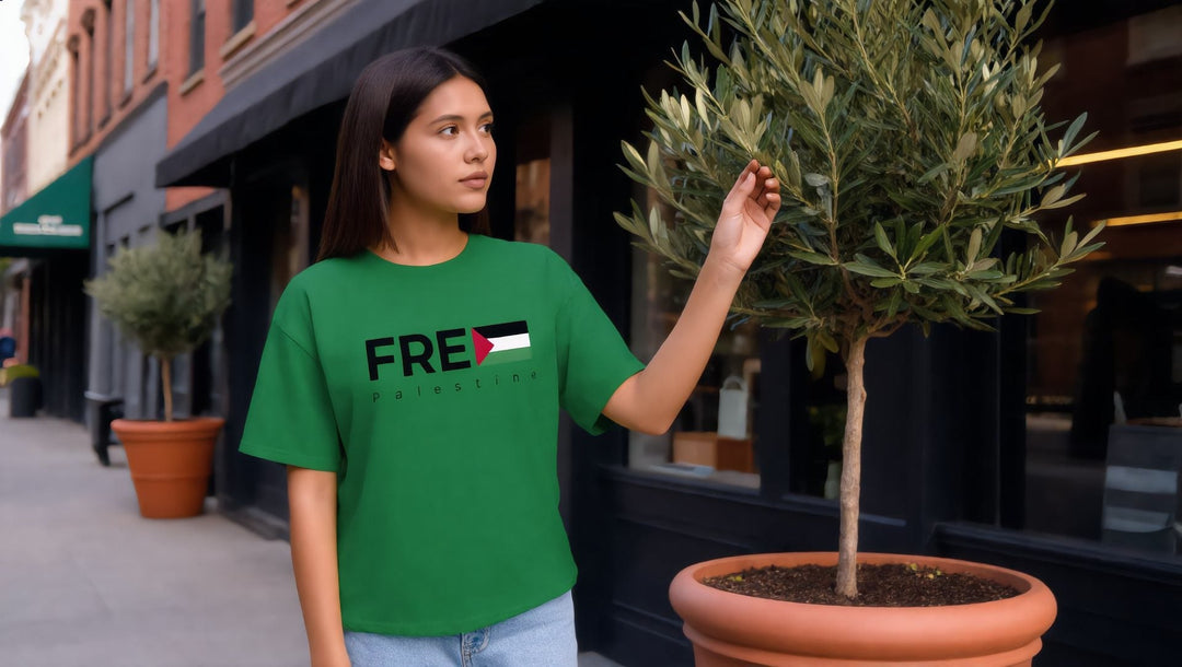 Woman in a green FREE Palestine t-shirt touching an olive tree in Brooklyn