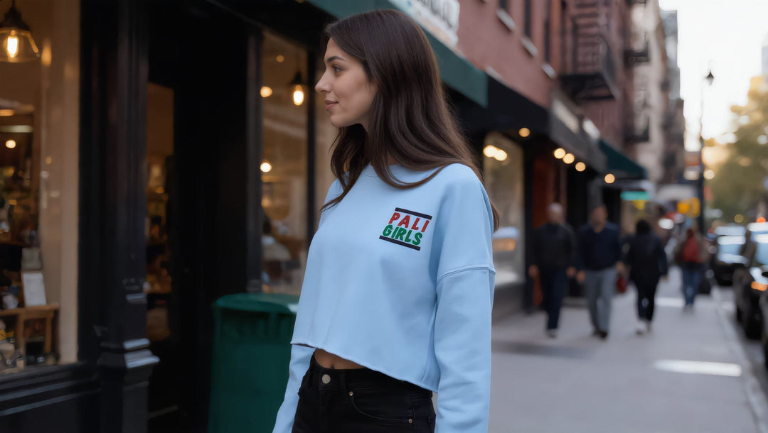 Woman in a Pali Girls embroidered crop sweatshirt on Bleecker Street, New York