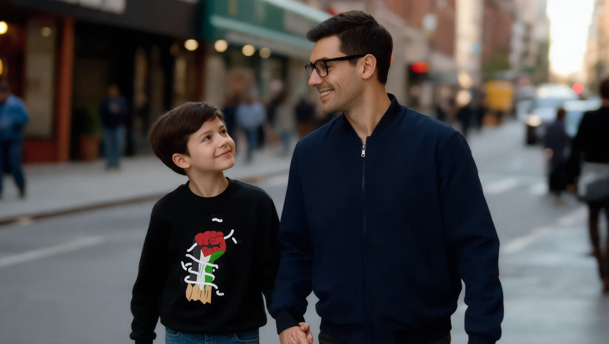 Father walking with a child in a black Palestine Hand kids sweatshirt on Atlantic Avenue, Brooklyn