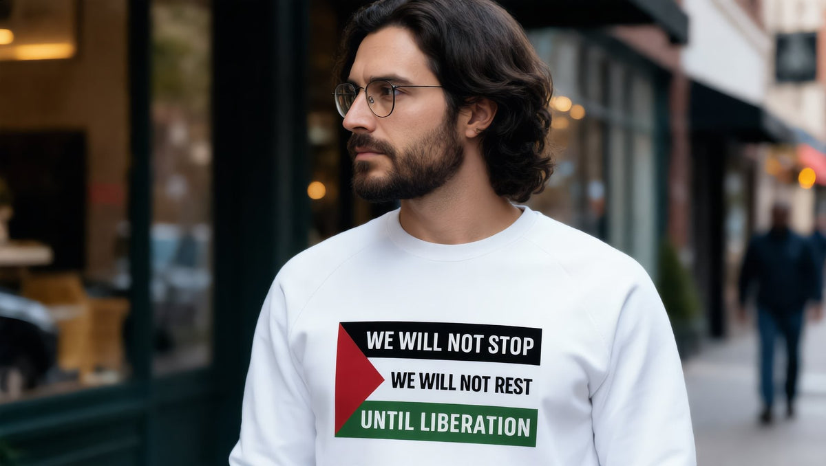 Man wearing a white We Will Not Stop raglan sweatshirt on Atlantic Avenue, Brooklyn