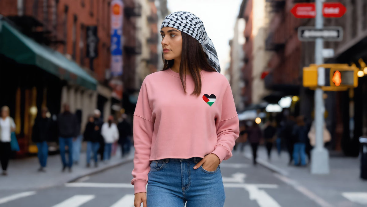 Woman wearing a pink cropped sweatshirt with a Palestine heart on Prince Street, SoHo, New York
